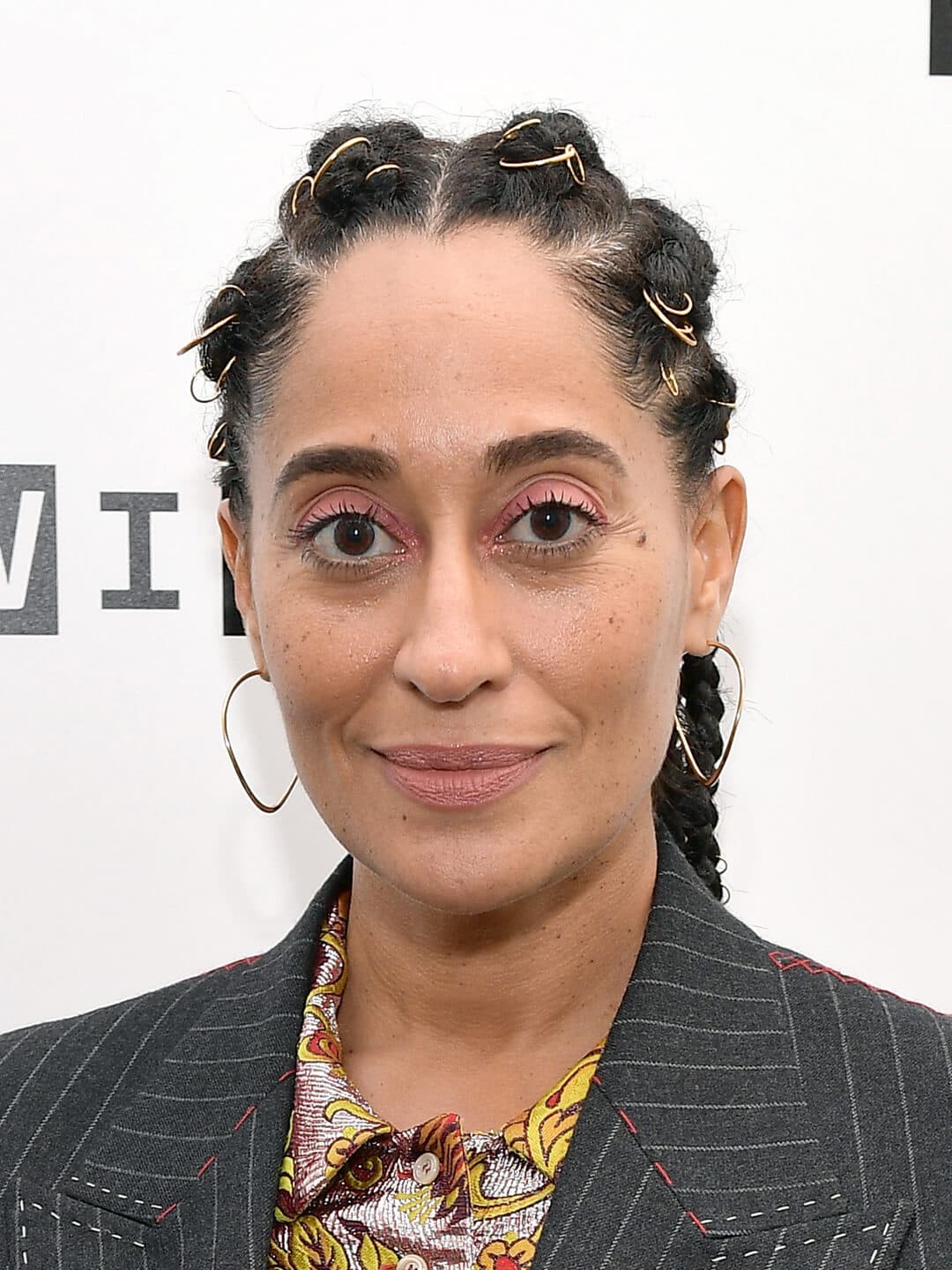 Tracee Ellis Ross in a gray suit rocking a gold-embellished braided hairstyle