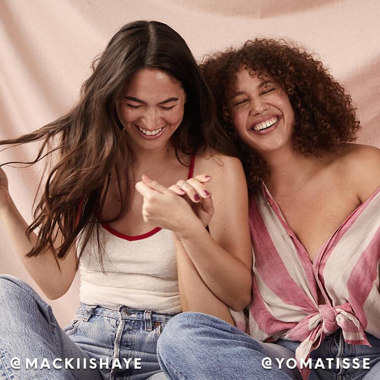 Models Mackii Shaye and Matisse smiling together while holding hands