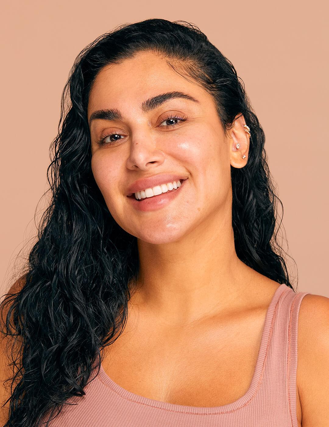 Close-up of Huda Kattan with damp hair and glowy bare face