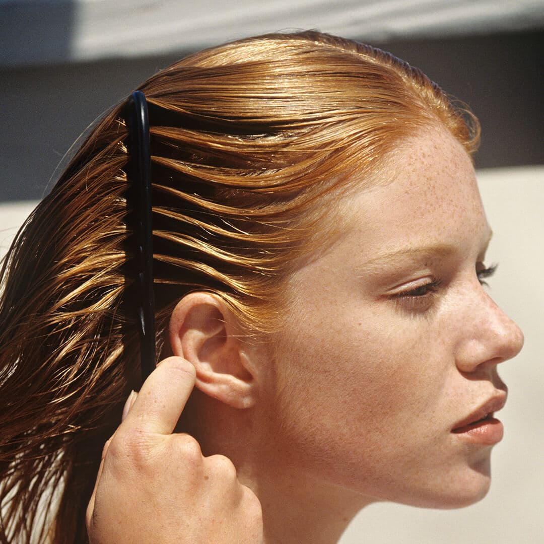 A photo of a woman combing her hair