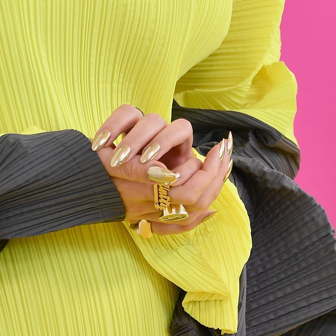 Close-up of Katy Perry's chrome nails against her slime green and dark gray dress