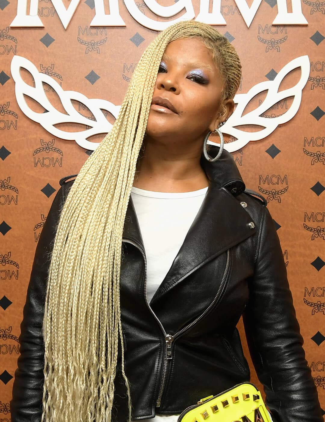 Misa Hylton rocking a blonde lemonade braids hairstyle, black leather jacket and white shirt inside, and silver eyeshadow makeup paired with nude lips