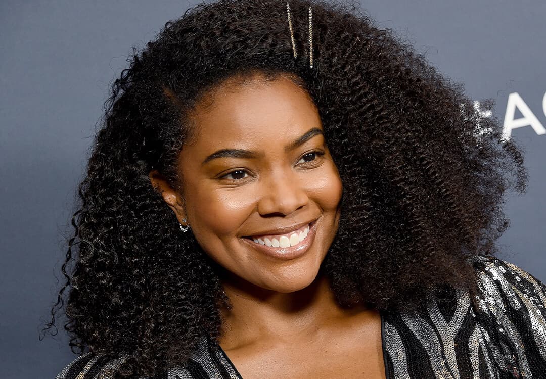 Gabrielle Union with a pinned back hairstyle smiling