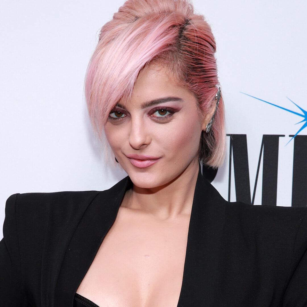 A photo of Bebe Rexha with pastel pink hair and dark pink roots
