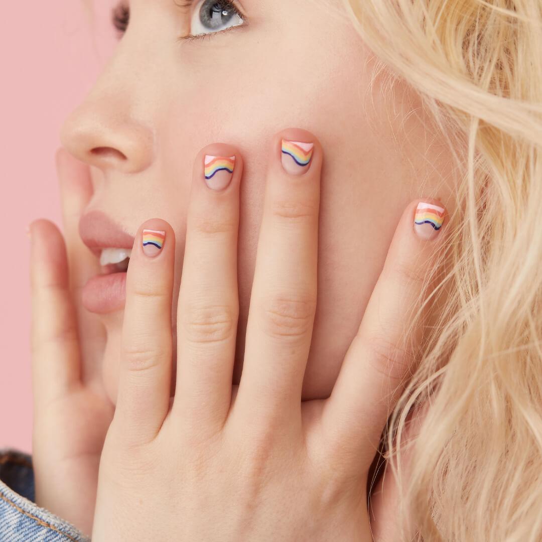 Close-up of a model showing off her rainbow waves nail art mani