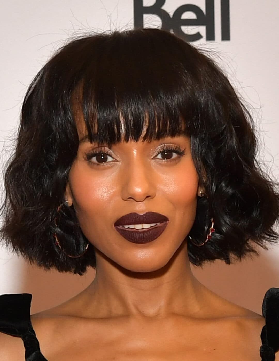 An image of Kerry Washington flaunting her black, wavy hair bob complimenting her dark, bold lipstick
