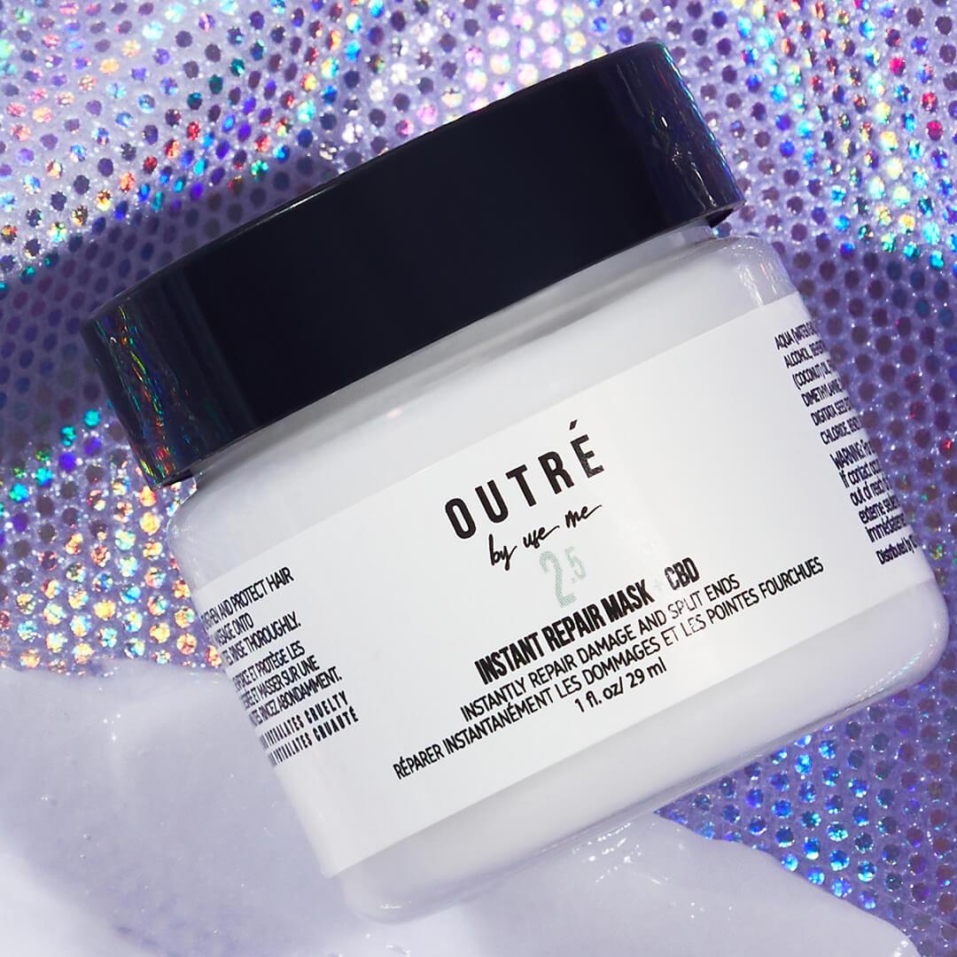 Close-up image of a jar of OUTRÉ BY USE ME Instant Repair Hair Mask + CBD on purple sequins background