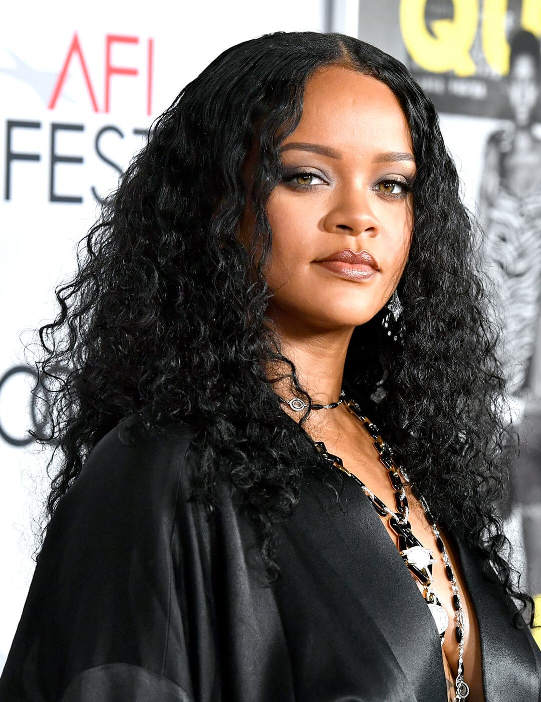 Rihanna in a black satin dress rocking a wet hair look 