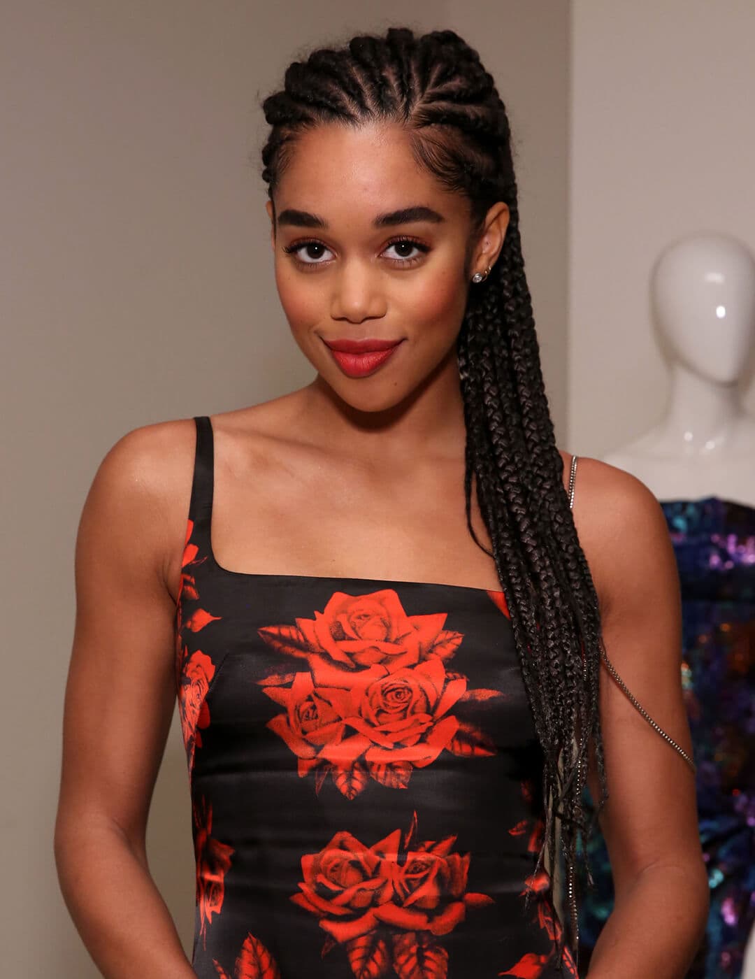 Laura Harrier looking chick in a black and red rose dress and braided hairstyle