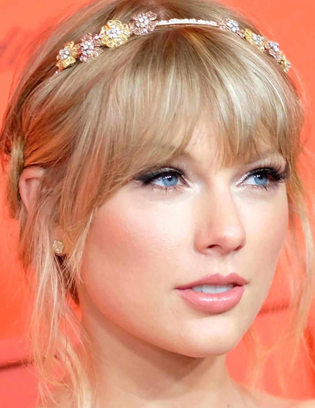 A photo Taylor Swift with a floral headband and pink blush and lip color