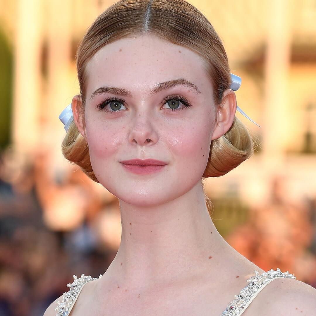 A photo of Elle Fanning with blonde hair and elevated pigtails