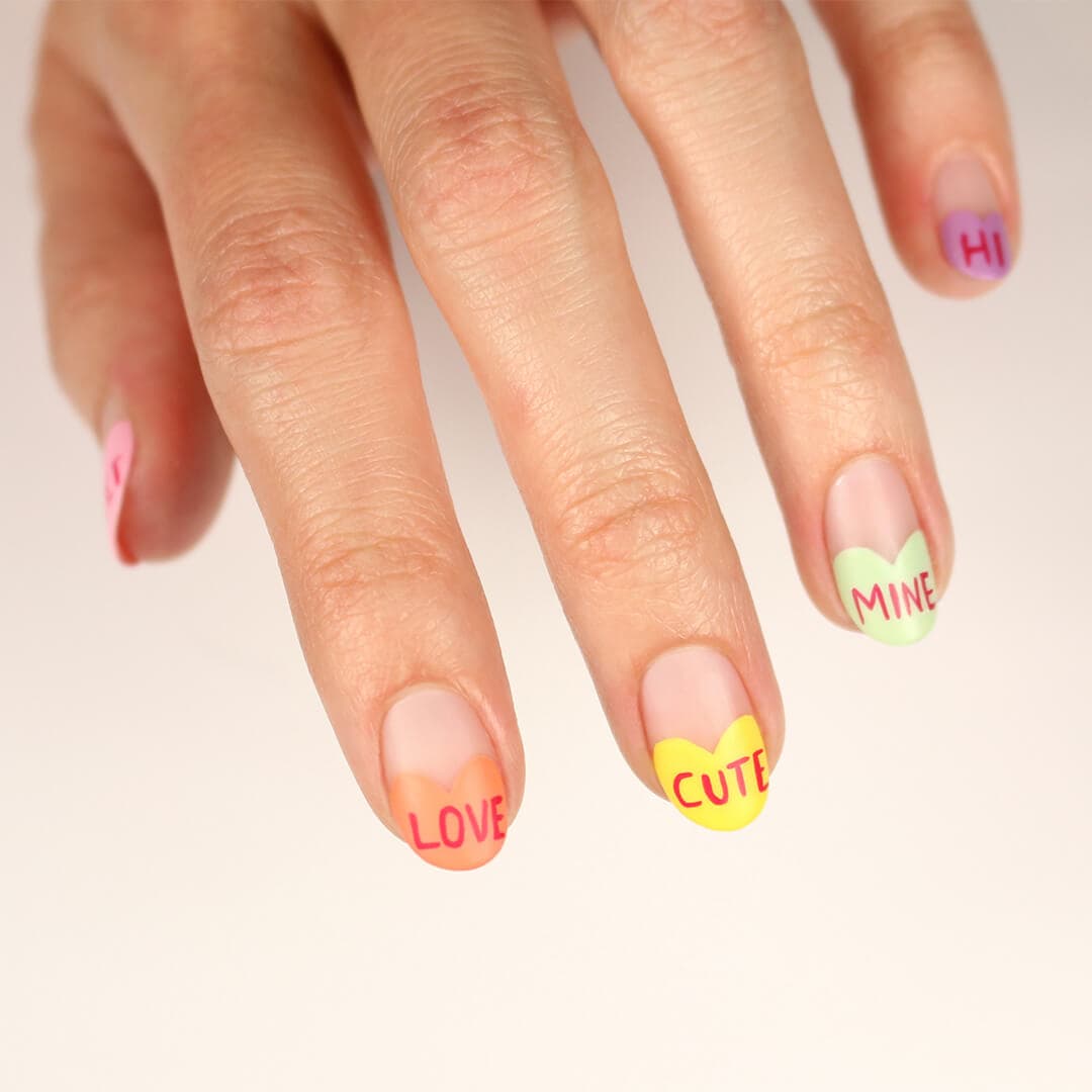 Image of model's hand with colorful nail art with words