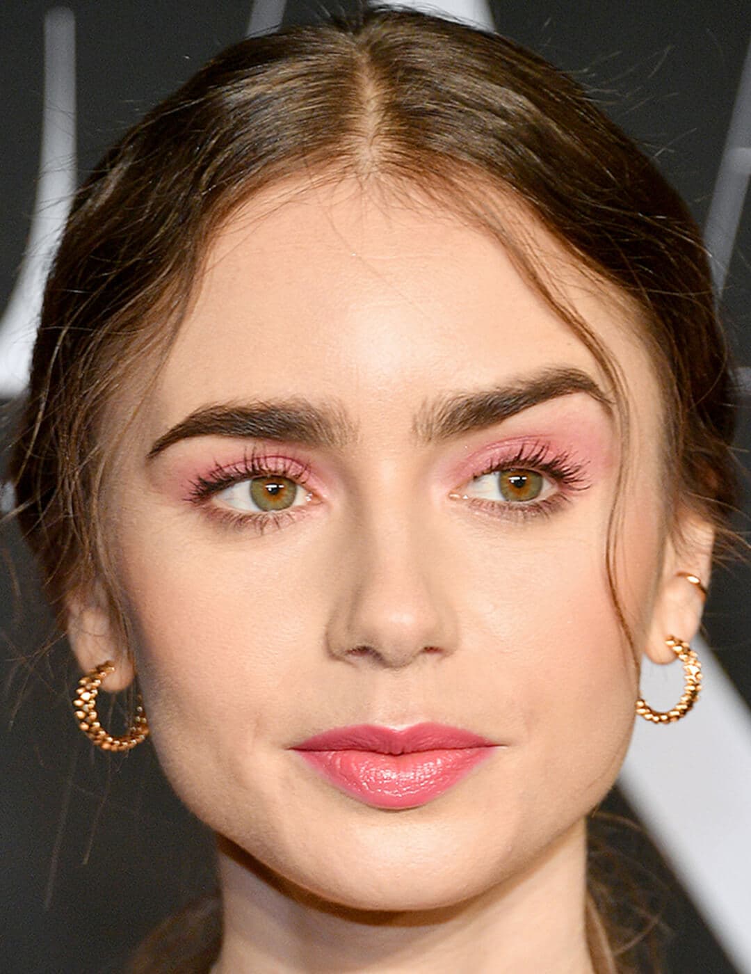 Lily Collins with a pink eyeshadow makeup look paired with nude lips