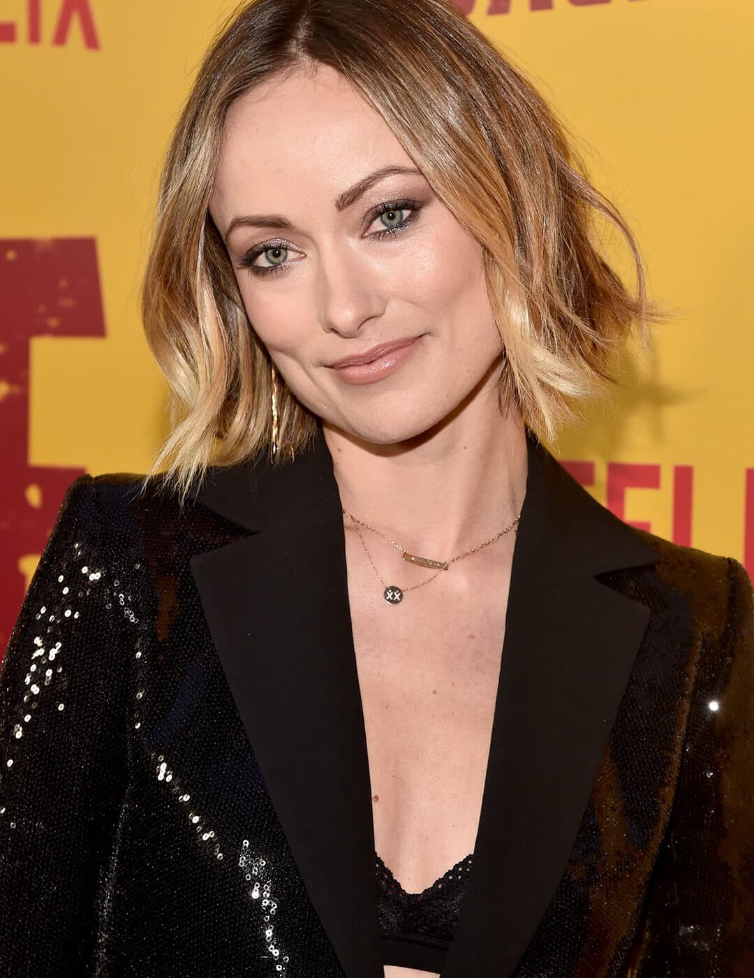 Olivia Wilde rocking a sequined suit, short balayage hair, and neutral makeup
