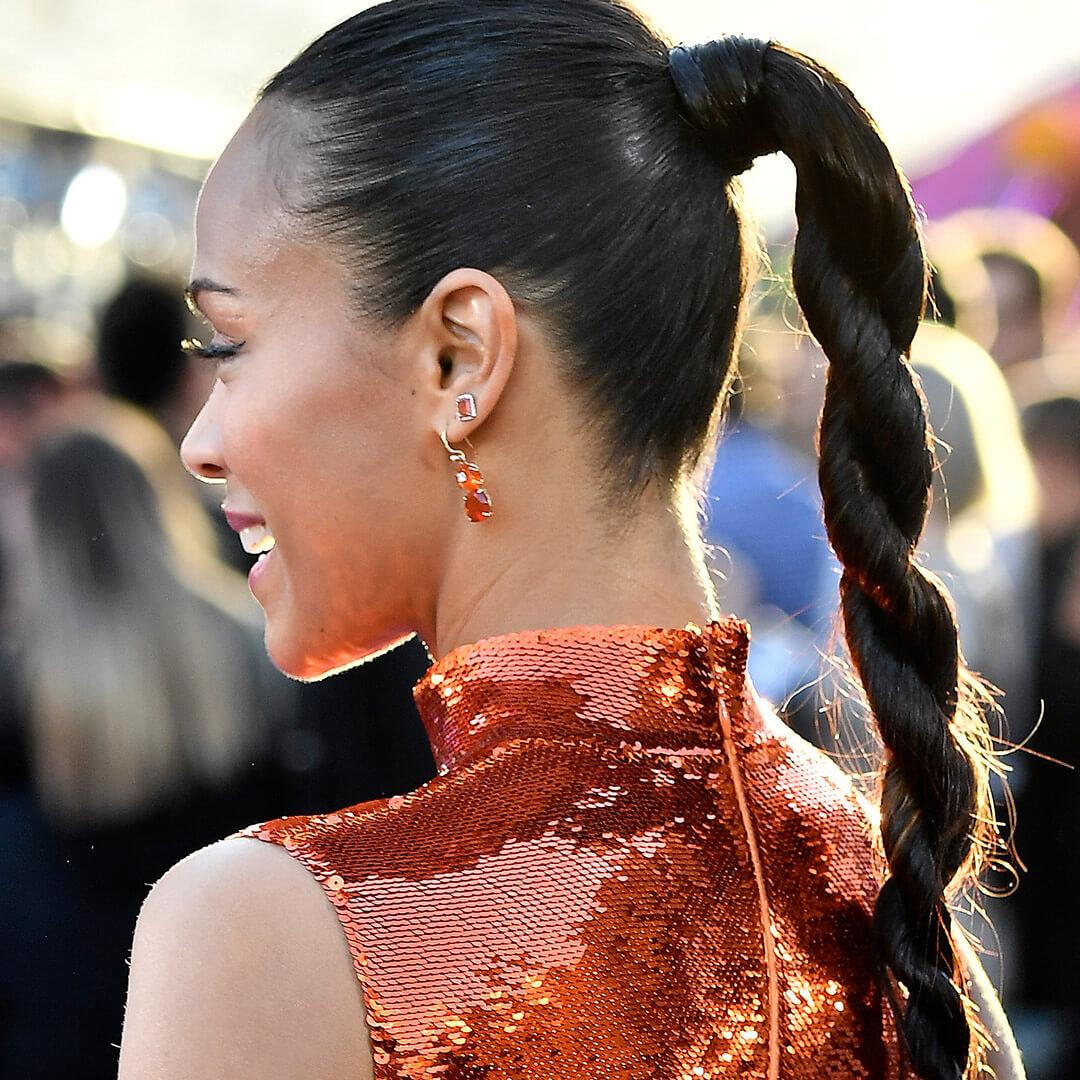 Zoe Saldana rocking a red-sequined dress and twisted ponytail hairstyle