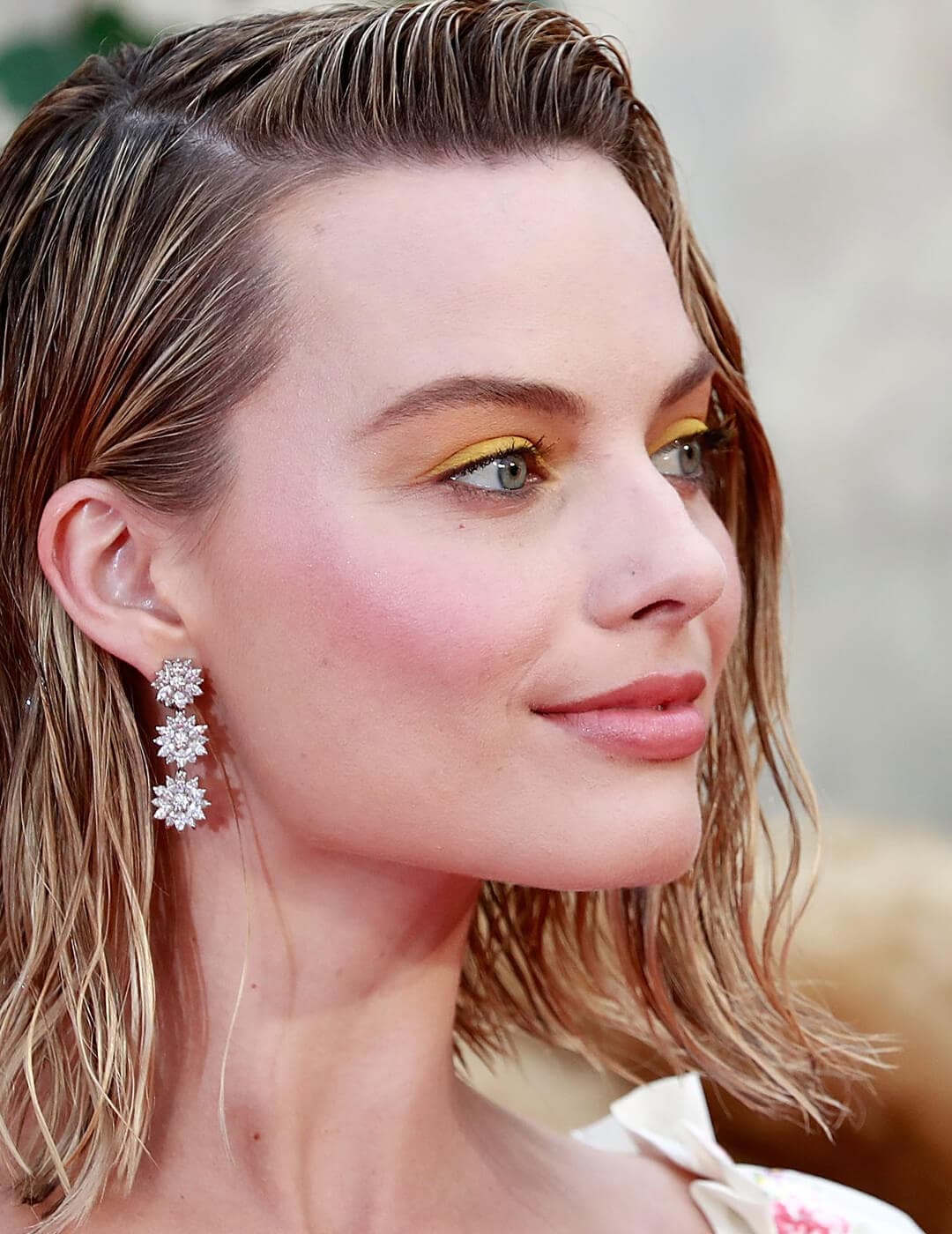Margot Robbie rocking a wet look hairstyle and buttery yellow eye makeup look
