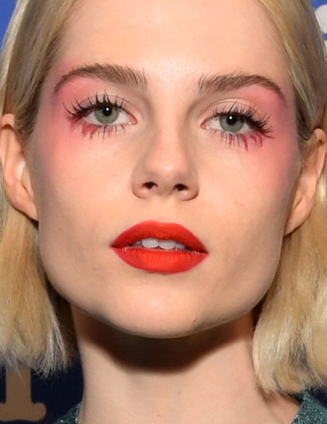 Lucy Boynton rocking a neon pink eyeshadow look and bold red lips