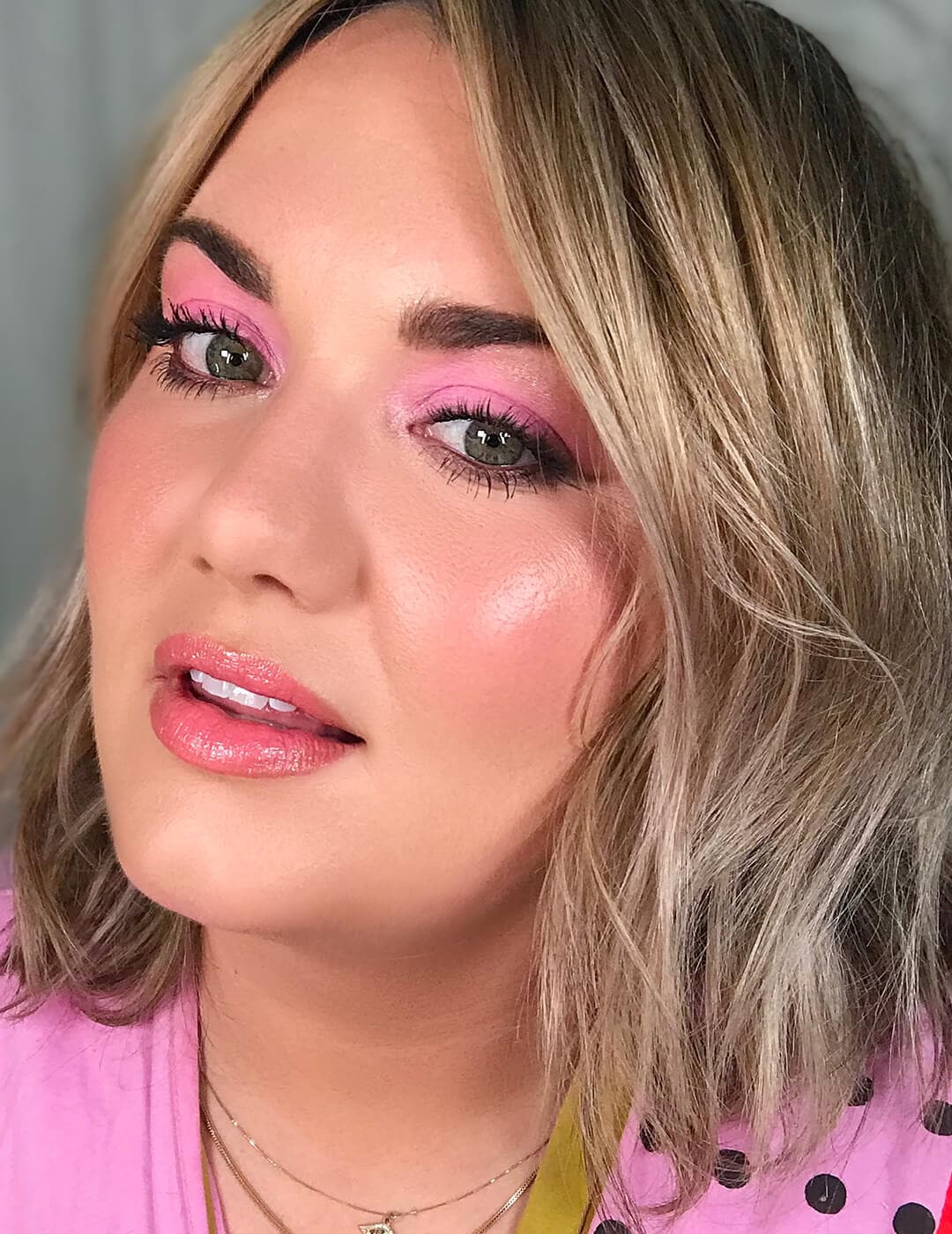 Close-up of a blonde woman rocking a neon pink eyeshadow look