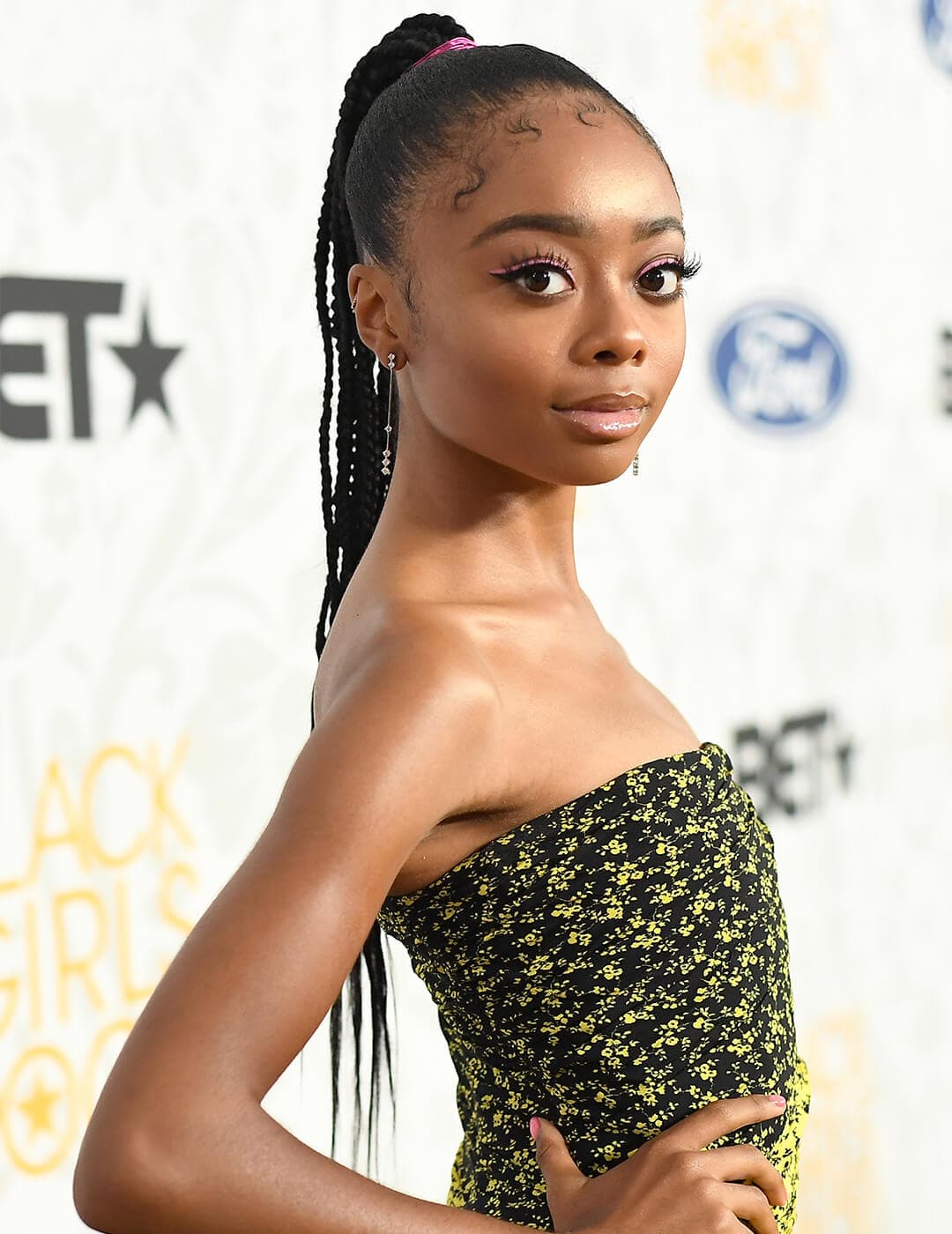 Skai Jackson looking glamorous in a yellow and black tube dress and braided ponytail hairstyle