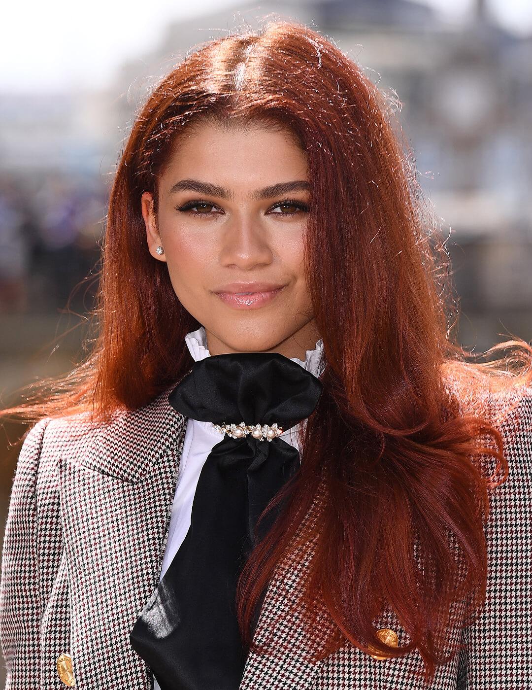A photo of Zendaya looking chic with a copper hair color