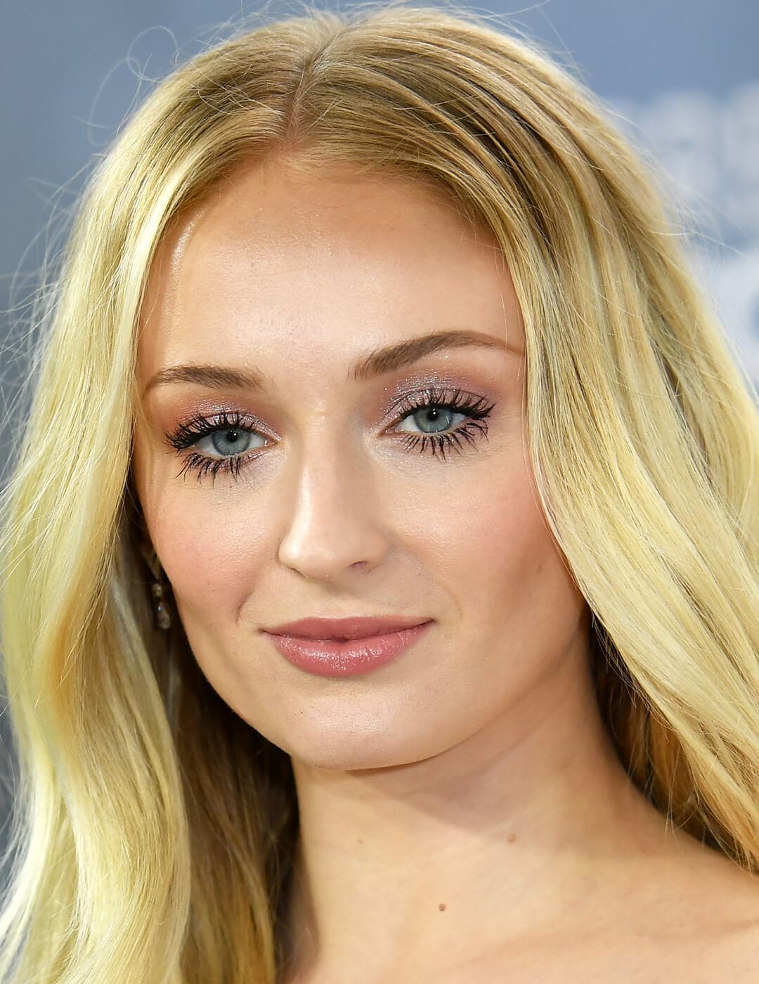 Sophie Turner rocking a shimmery mauve eyeshadow makeup look and bold fluttery lashes on the red carpet