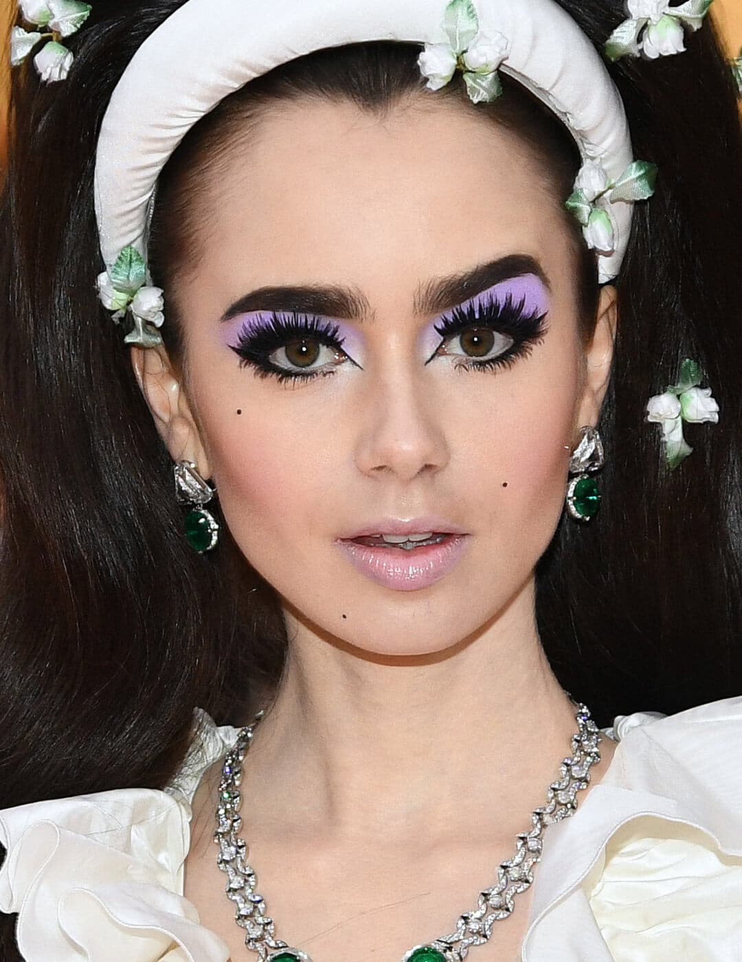 Lily Collins rocking pastel lilac eyeshadow and bold eyeliner and eyelashes makeup look 