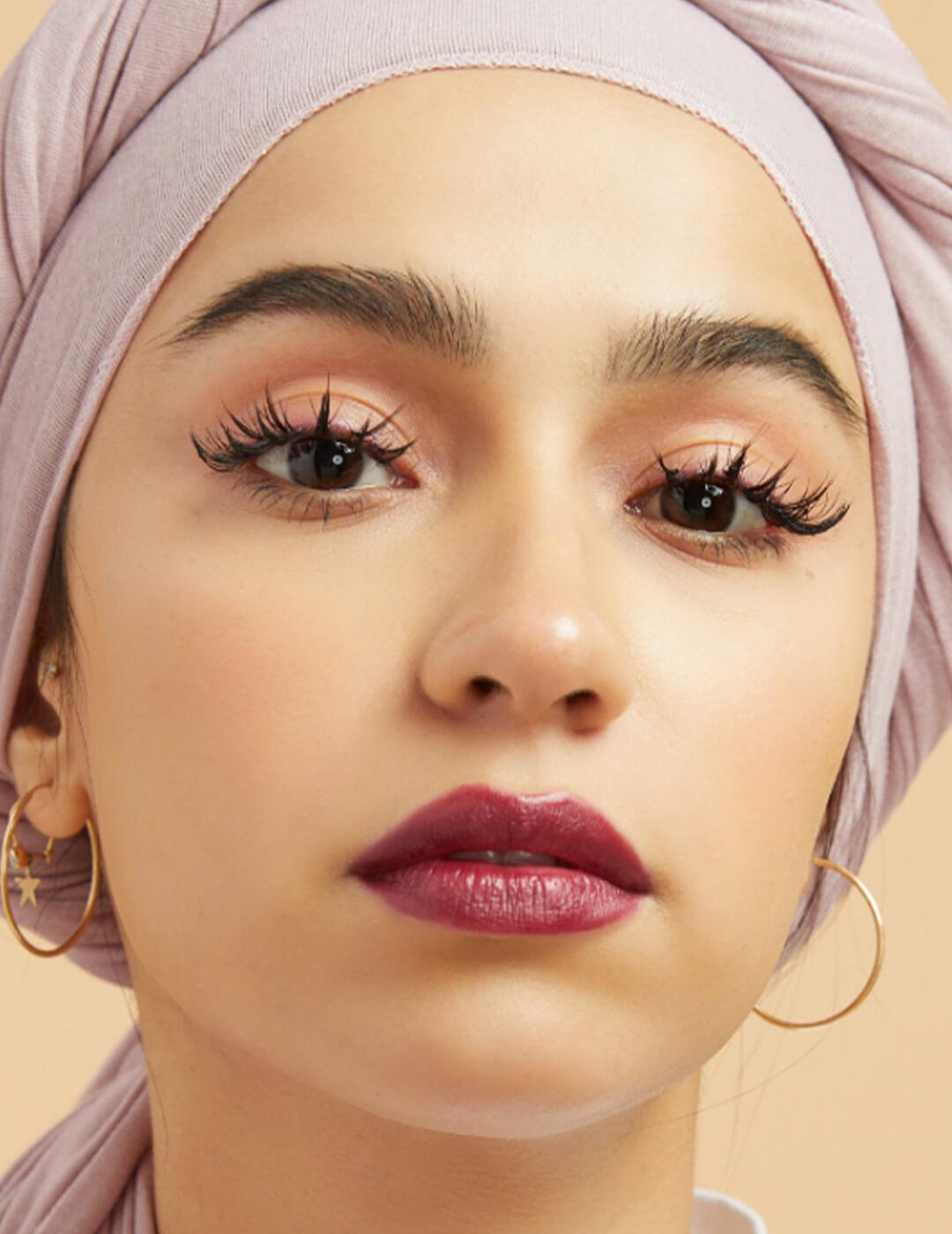 Close-up of a model with a stiletto lashes and berry lips makeup look