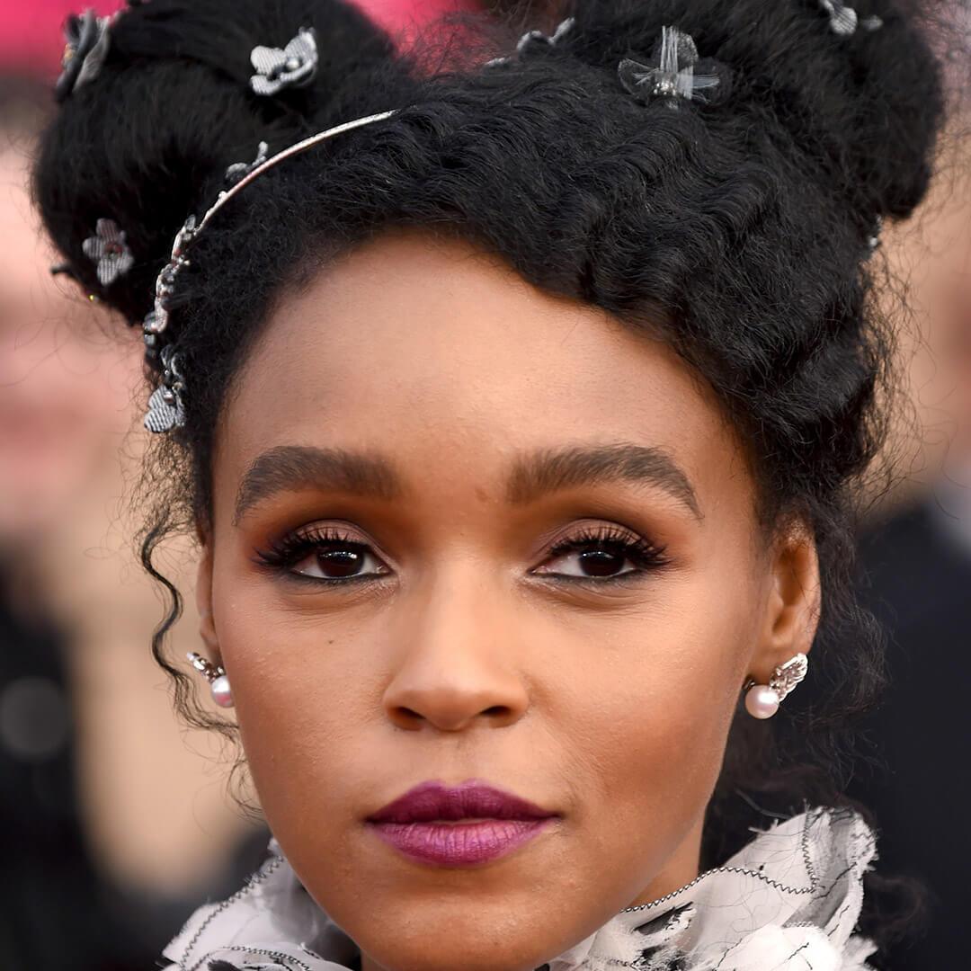 A photo of Janelle Monae space buns and floral hairpins