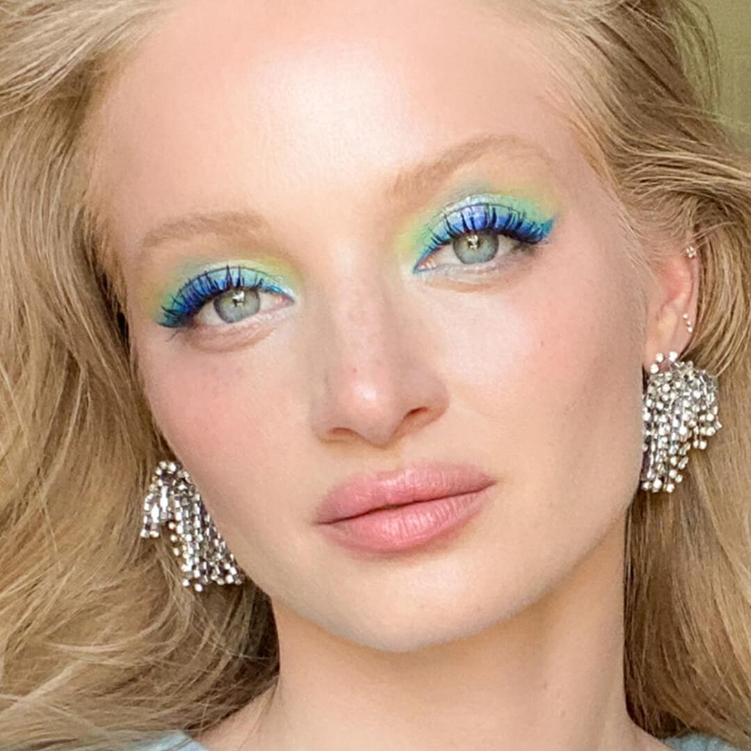 Close-up image of a tropical blue, green, and yellow eyeshadow look on Ash Walker