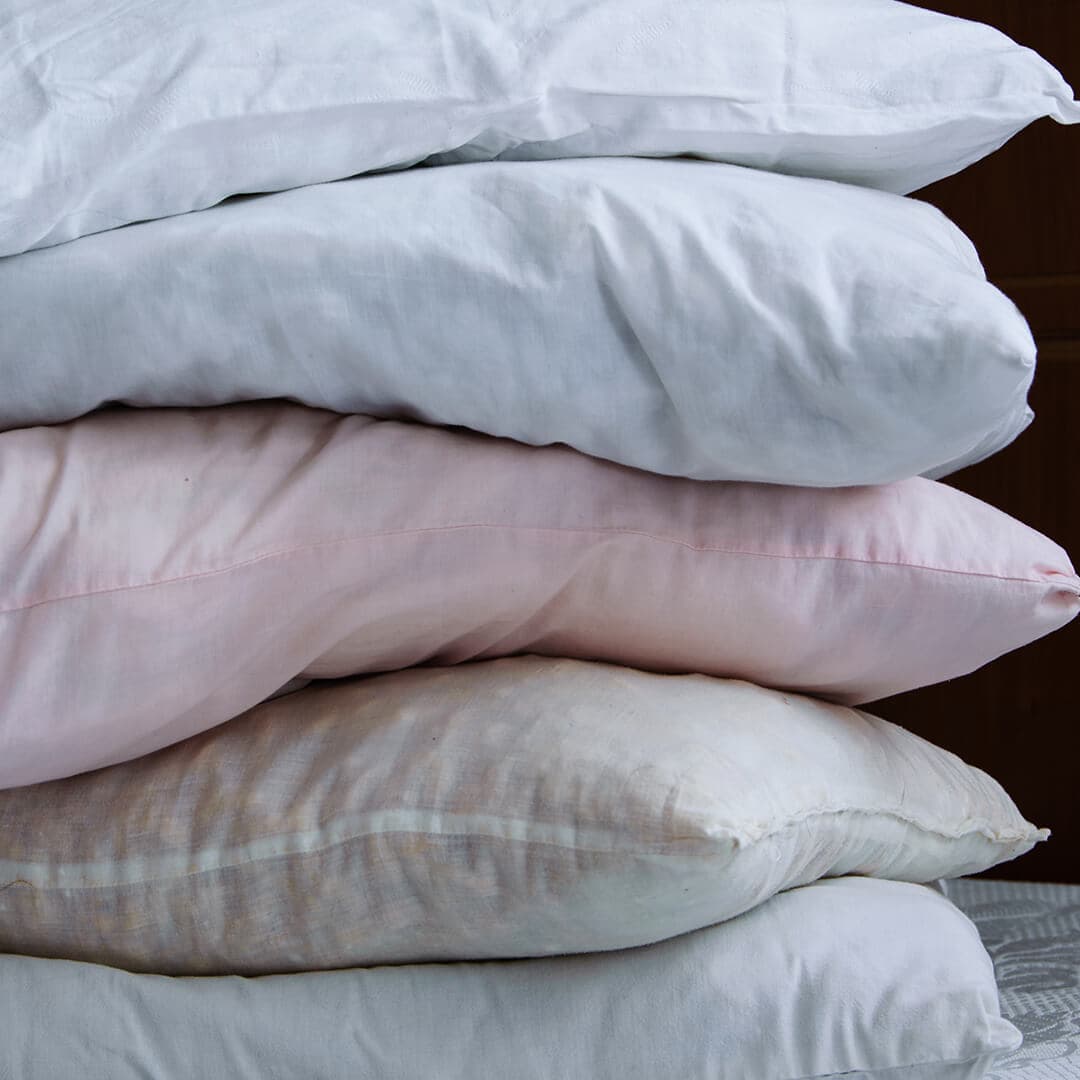 A closeup photo of stacked pillows on a bed