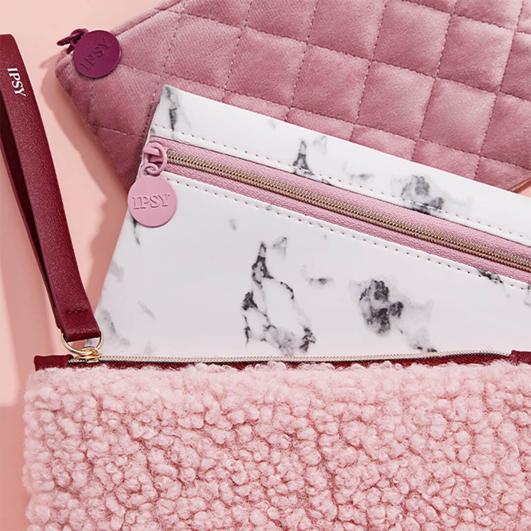 Pink-themed IPSY Glam Bags arranged on pink background