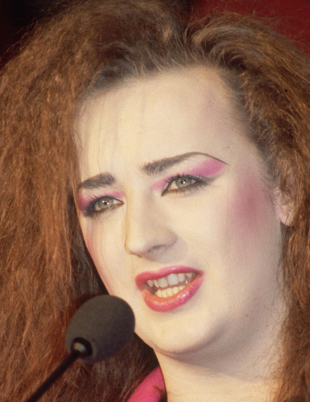 A photo of Boy George rocking a neon stripe of pink shadow with a bright metallic pink lip