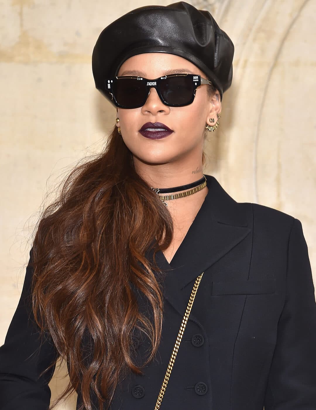 Rihanna in an all-black ensemble with a side ponytail hairstyle