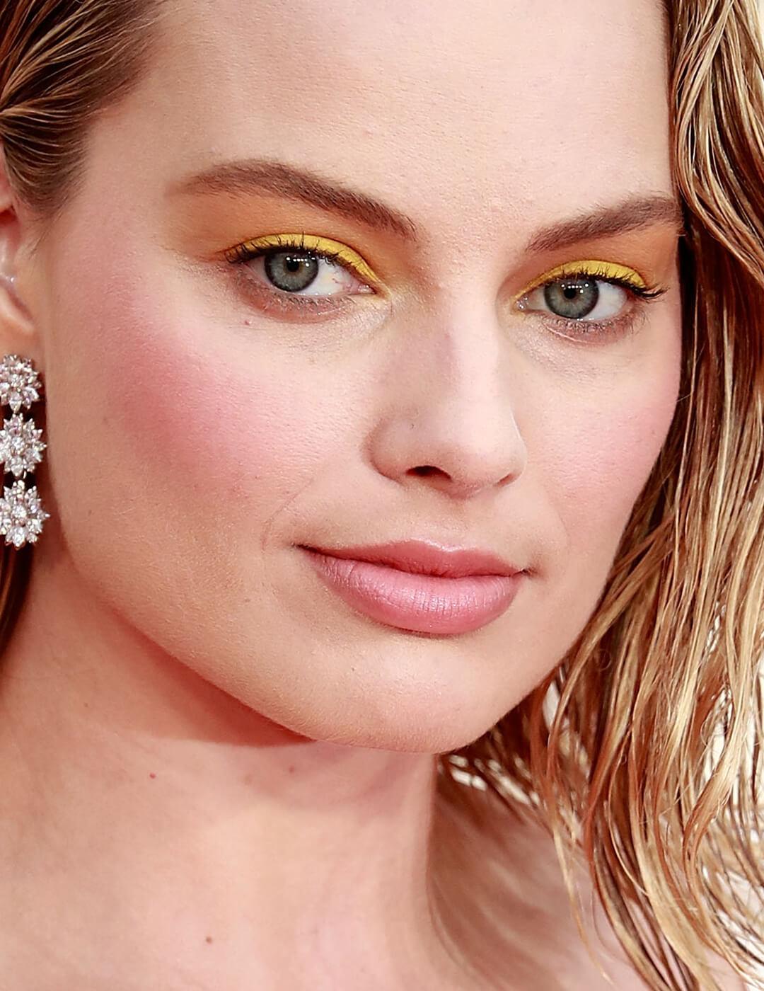 Margot Robbie rocking a yellow eyeshadow look and nude pink lips