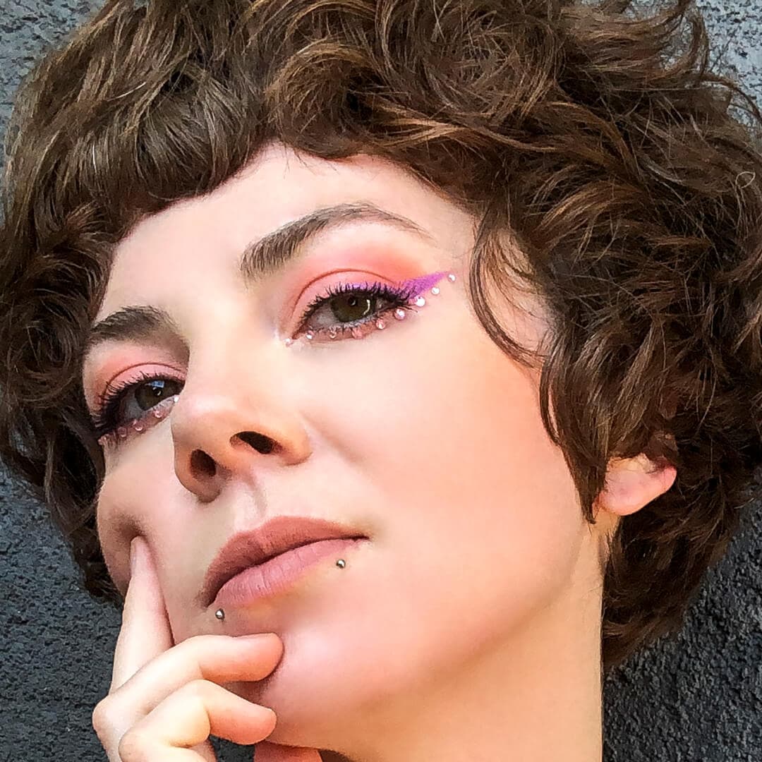 Close-up image of Kirsten Colemen rocking a pink rhinestone makeup look