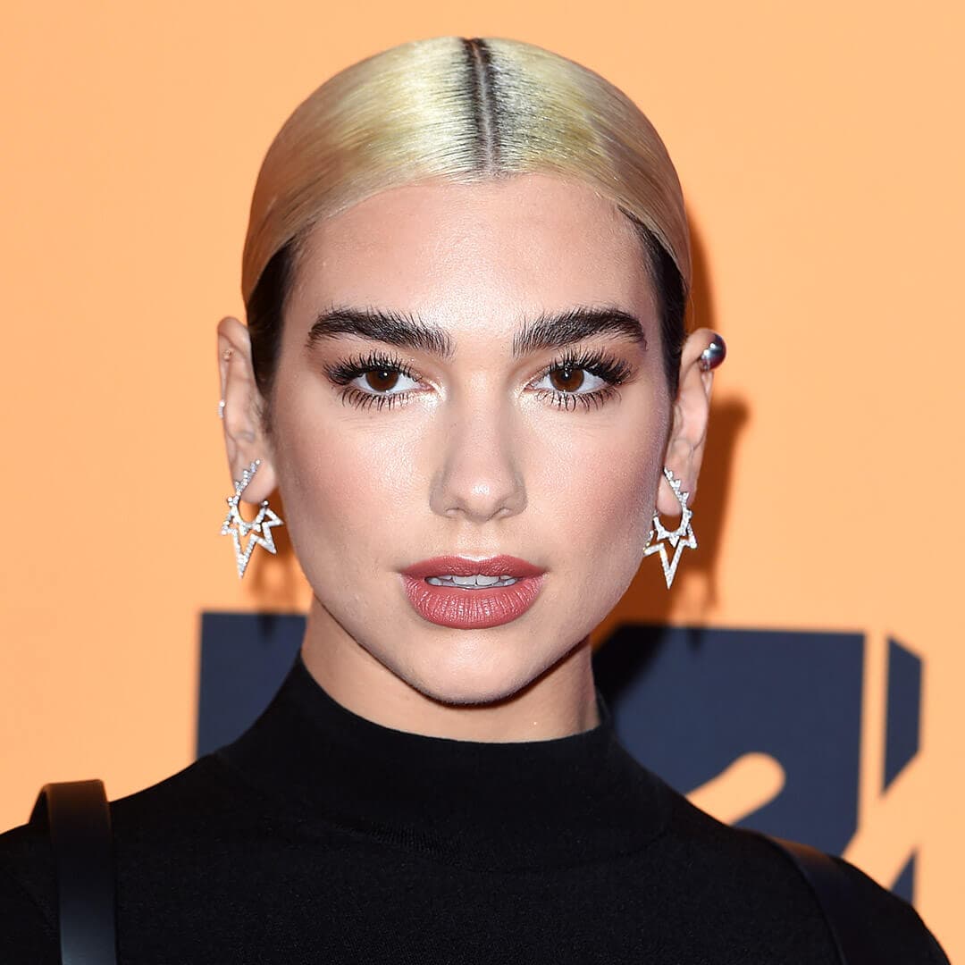 A photo of Dua Lipa with middle parted hair and a low bun