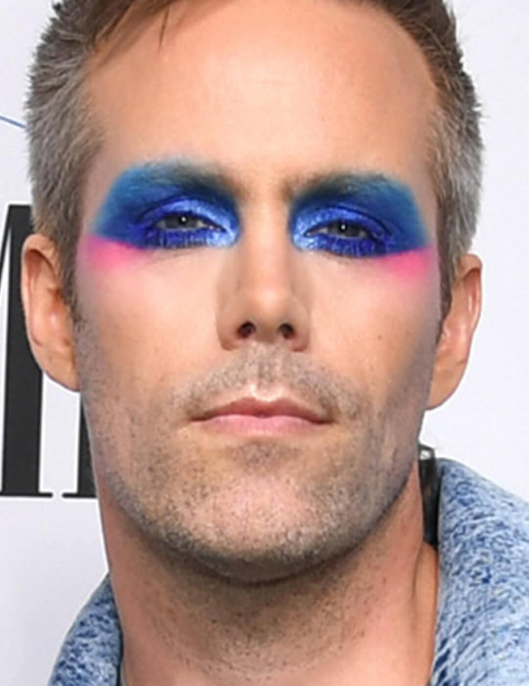Justin Tranter in bold blue eyeshadow makeup