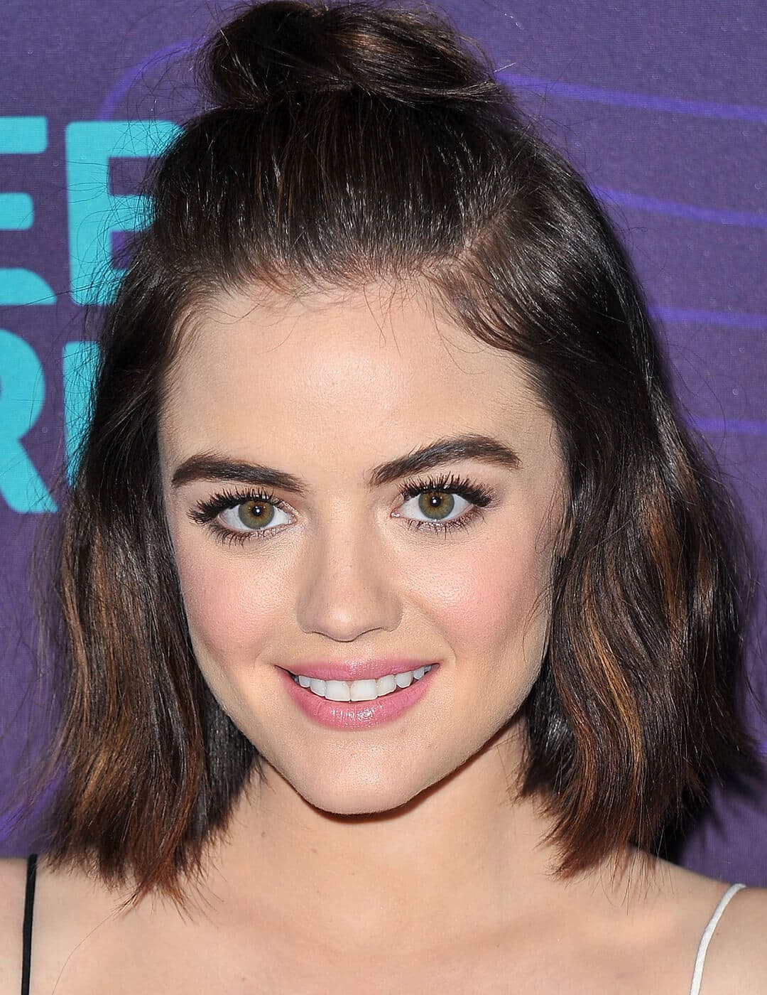 A photo of Lucy Hale with a tiny top knot hairstyle