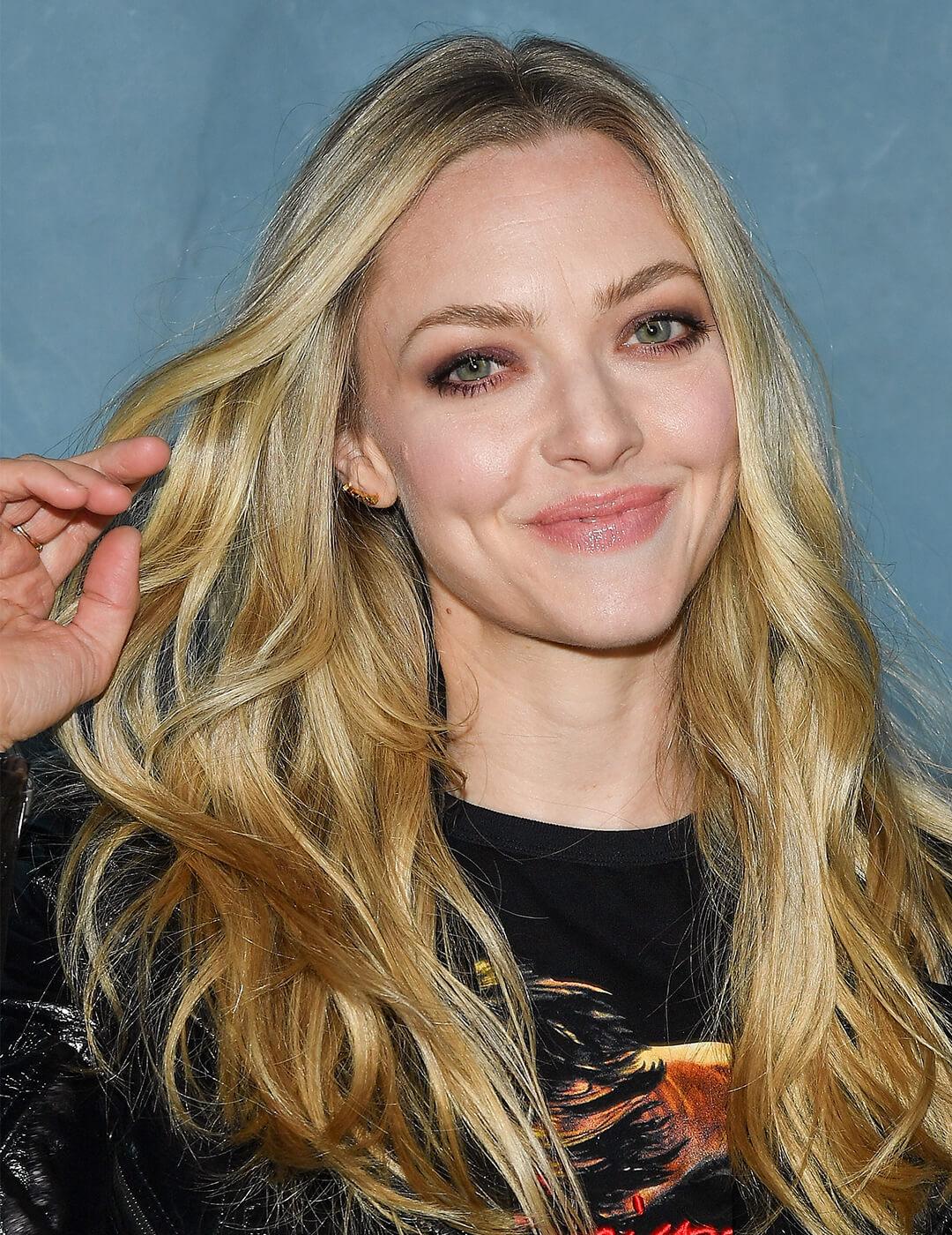 A photo of Amanda Seyfried with a layered style blond hair wearing a black shirt