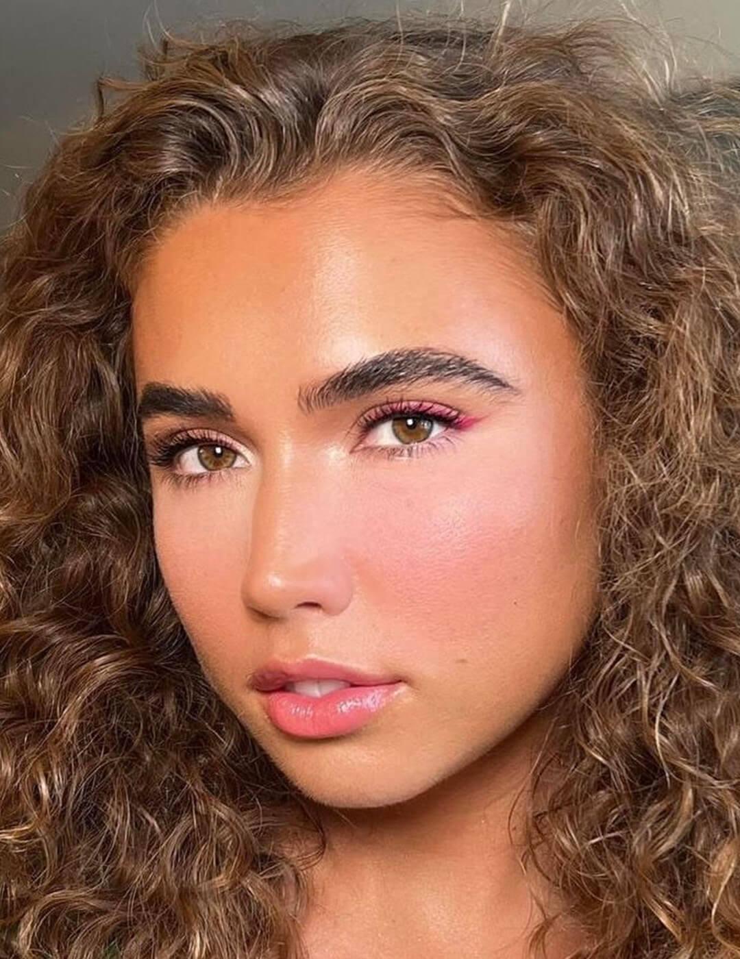 A closeup photo of a model with a pink pop makeup look