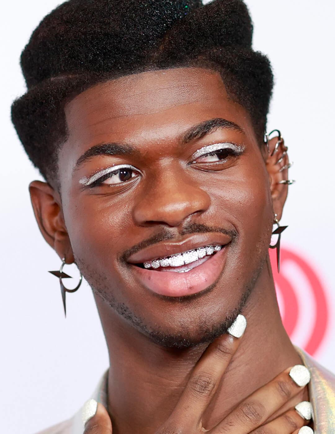 Lil Nas X rocking a glittery winged eyeliner makeup look and white nails