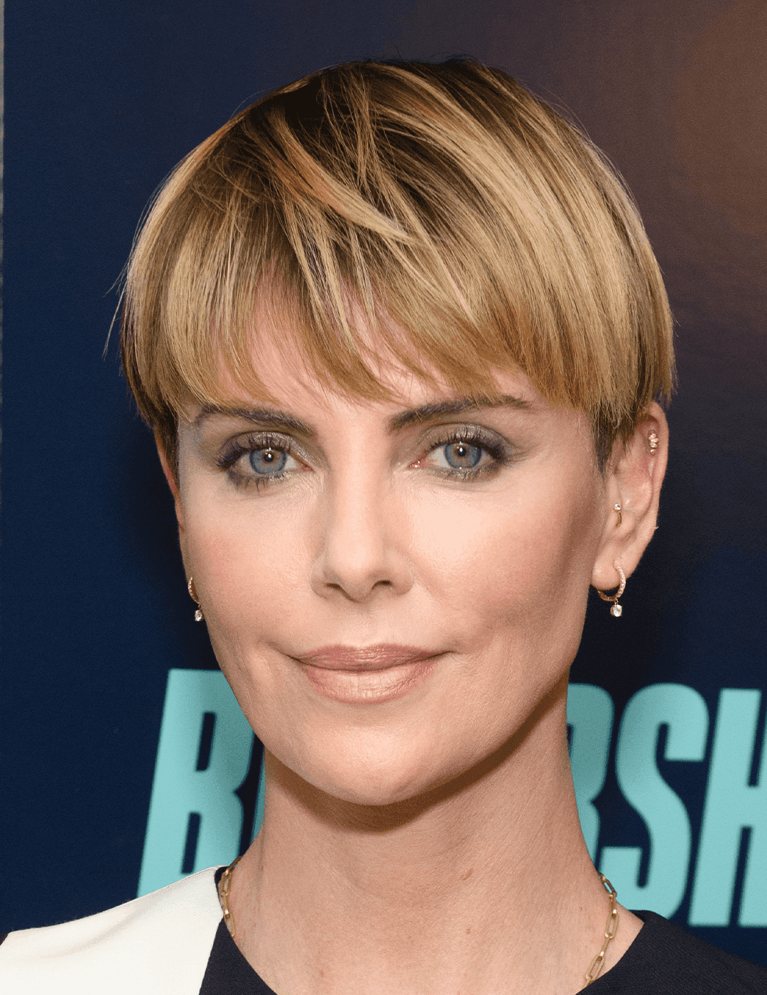 Charlize Theron rocking a bowl cut hairstyle and soft smoky eye makeup look