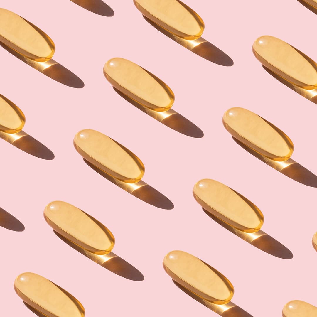 A photo of capsules diagonally lined up on a pink paper