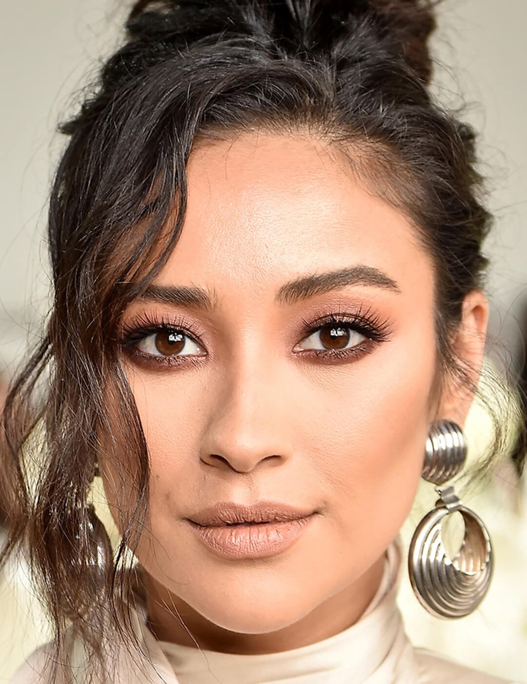 Close-up of Shay Mitchell with a smoky eyeshadow makeup look paired with matte nude lips