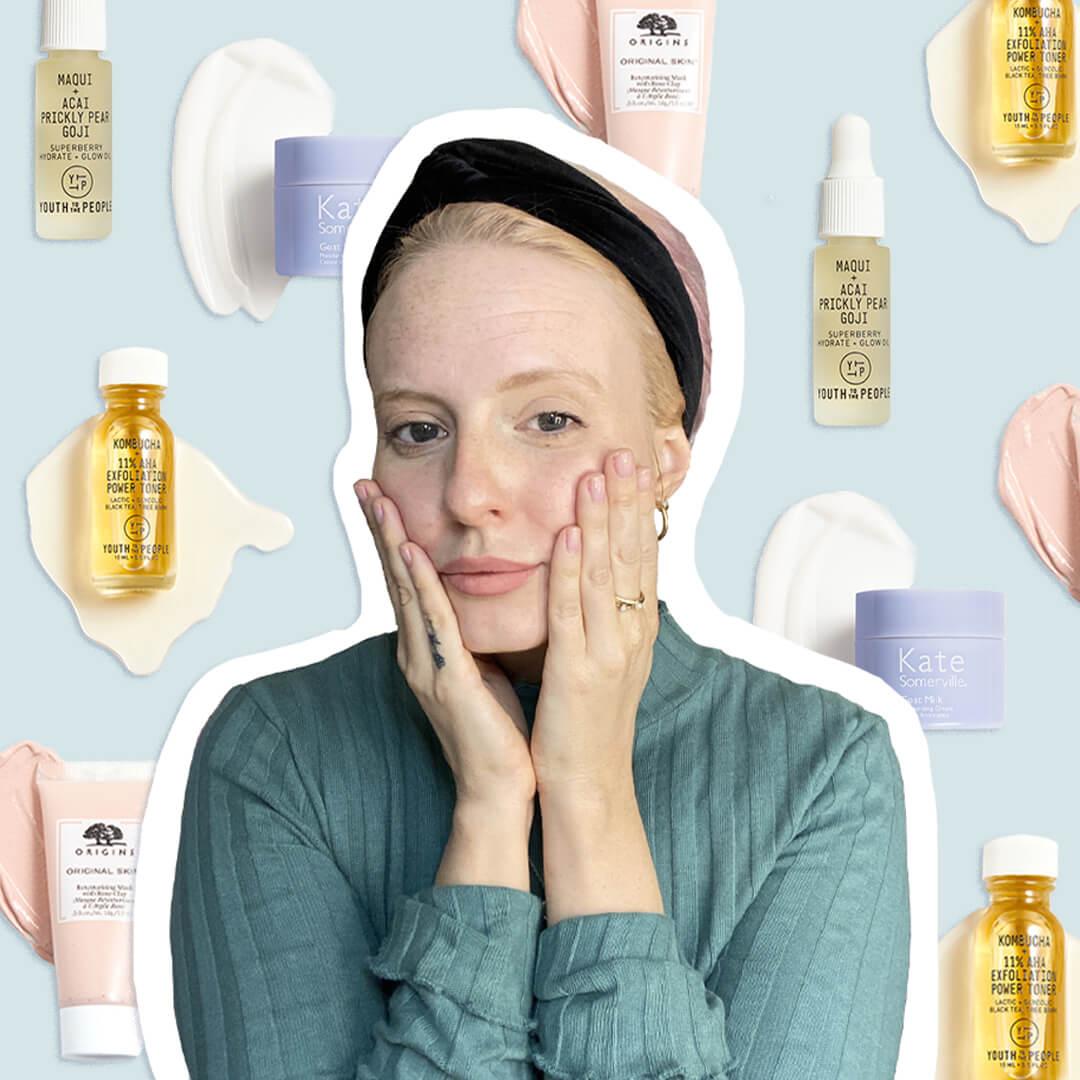 Close-up image of Hannah Cassidy touching her face with her hands and wearing a green sweater and black headband on skincare products background