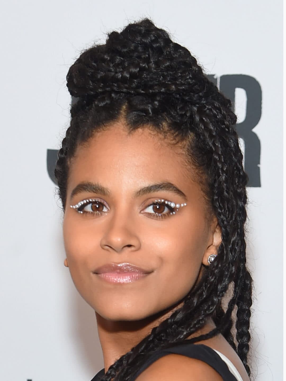 Zazie Beetz looking glam with a pearl-studded eyeliner look and half up braided hairstyle
