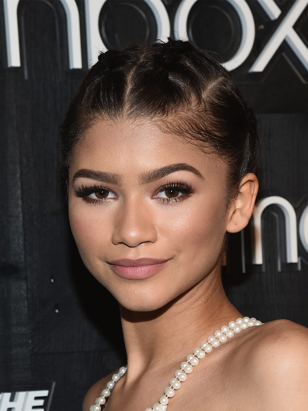 Close-up of Zendala looking glam in a braided updo hairstyle and sultry makeup