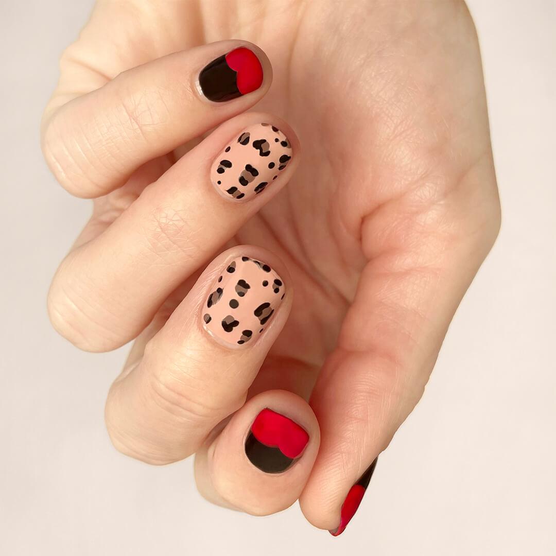Close-up of a model's hand with nail print and black and red nail art