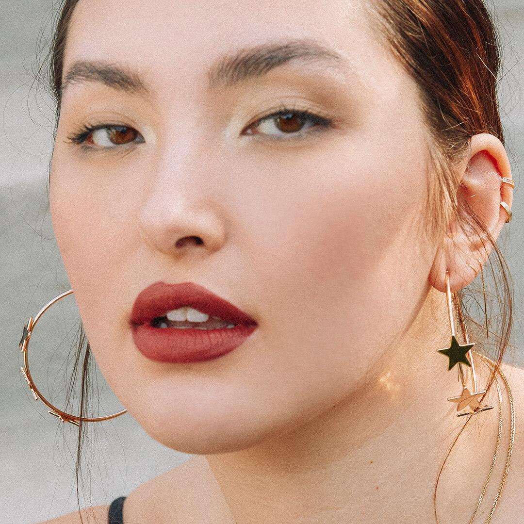 Close-up of a woman rocking a deep red lip and glossy eye makeup look