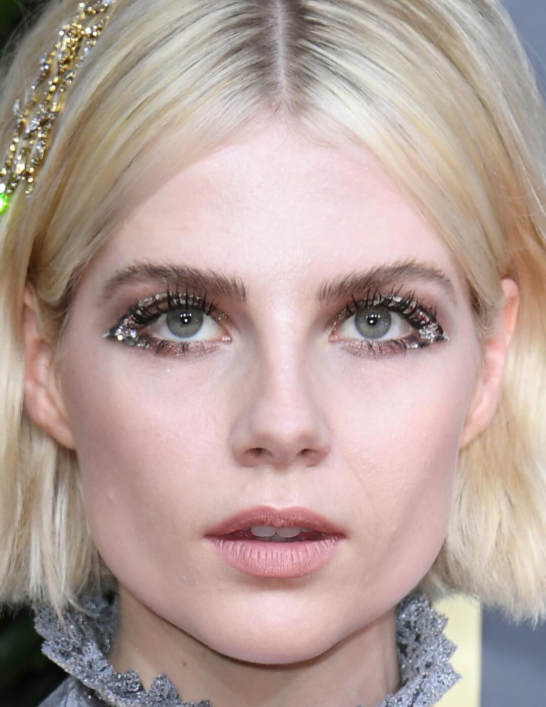 Close-up of Lucy Boynton rocking a winged eyeliner look filled in with sequins